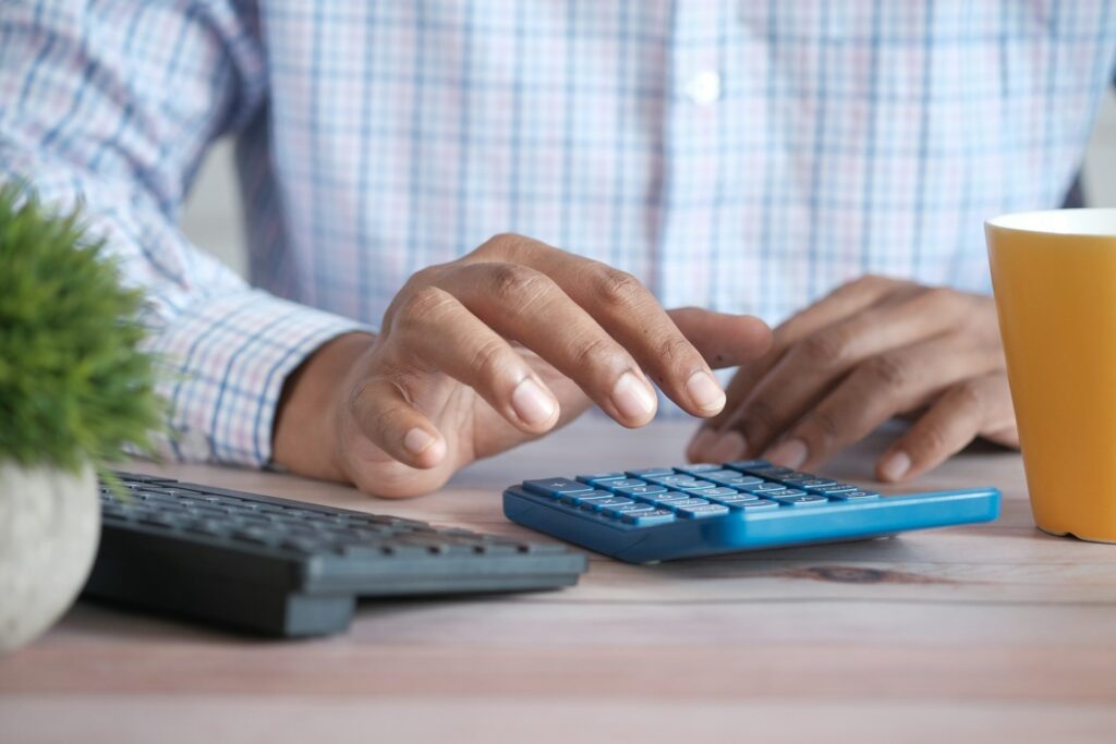 Hands working out costs on a calculator