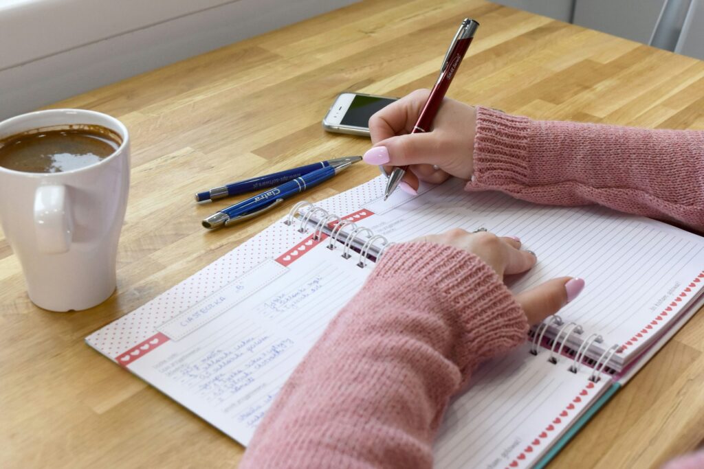 Person writing notes in a notebook